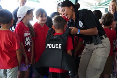 On May Day, District Attorney Investigator Erika El-Helou providing a unique opportunity for students to try on law enforcement gear firsthand, fostering a deeper understanding and appreciation for the work of officers.